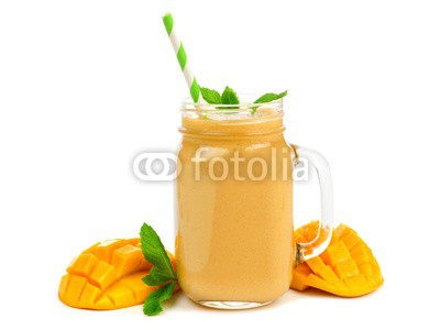 Mango coconut smoothie in a mason jar glass with mint and straw isolated on white