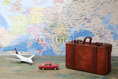 Trip or traveling by airplane concept. Miniature toy airplane and suitcases on map.