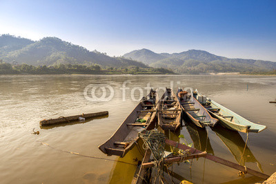 Traditional old wooden fishing boat floating on Mekong river in North Thailand, outdoor day light