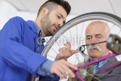 Men looking at bicycle chain