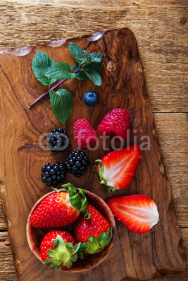 strawberry and berries on wooden cutting board
