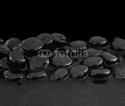 Black stones on calm water background