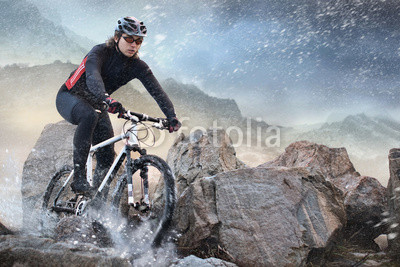 Cyclist climbing on a rock