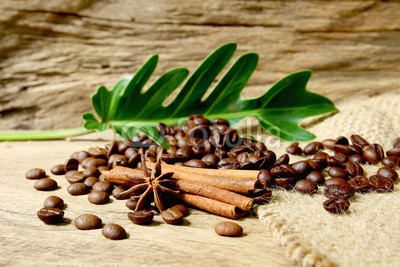 Roasted coffee beans  on sackcloth with grunge wooden  backgroun