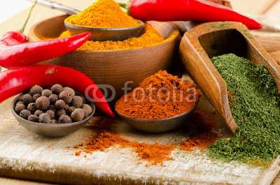 spices on spoons on  wooden background