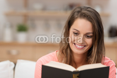 glückliche frau liest ein buch zu hause