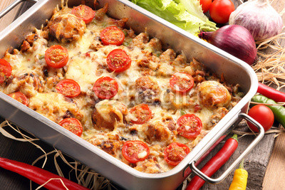 Casserole with rice meatballs and vegetables on wooden backgroun