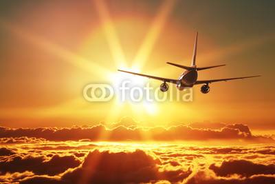 Plane is taking off at sunset