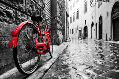 Retro vintage red bike on cobblestone street in the old town. Color in black and white