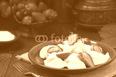 Delicious dumplings with fresh strawberries served with whipped cream and sugar.