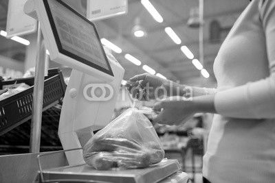 woman weighing potatoes on scale at grocery store