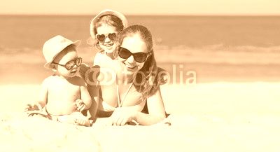 Happy family mother and children play and laugh on beach