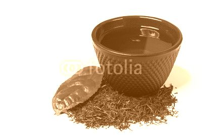 Cup and heap of green shincha tea with leaf.