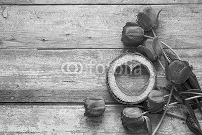 Background with red tulips and wooden hearts on old wooden boards.