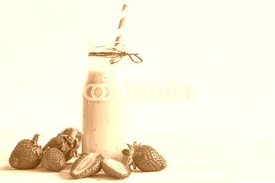 Strawberry smoothie or milkshake in a bottle with straw