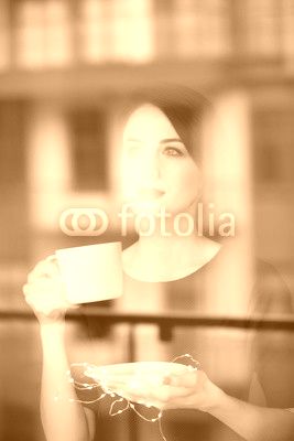 Beautiful redhead woman with cup of coffee or cappuccino near a