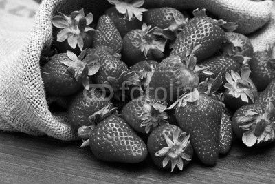 fresh strawberry in burlap sack on wood