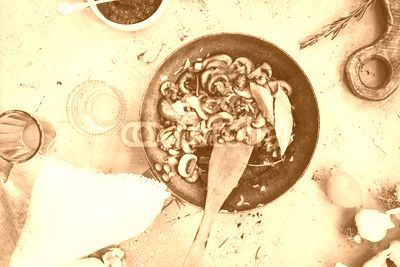 Fried mushrooms cast-iron pan on table.