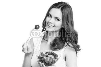Close-up of pretty girl eating fresh vegetable salad.