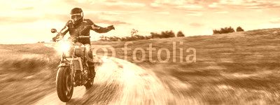Motorrad fährt auf freier Landstrasse in den Sonnenuntergang