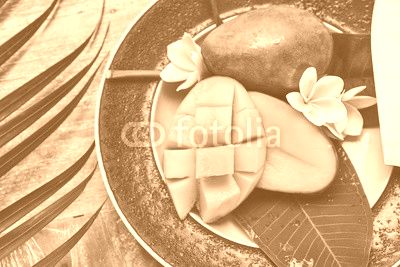 Fresh mango on a wooden tabel with tropical background. Soft focus.
