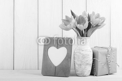 Fresh pink tulips, blank frame and gift box