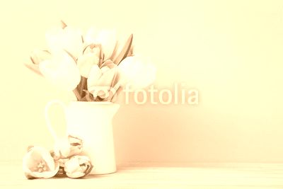 Bouquet of tulips in jug on green background