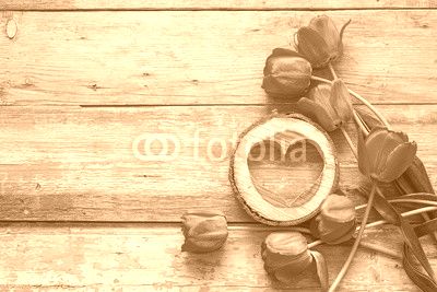 Background with red tulips and wooden hearts on old wooden boards.
