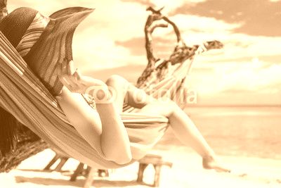Frau im Urlaub am Strand entspannt in Hängematte am Meer