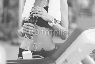 Slim woman holding a bottle after workout