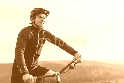 Young male riding bicycle among mountains