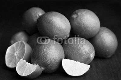 Fresh juicy limes on wooden table, on dark background