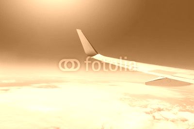 wing of an airplane flying high in the sky above the clouds