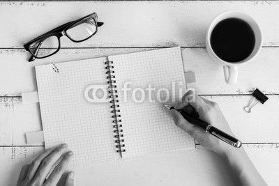 Cup of coffee with notebook and copy space on white wooden desk
