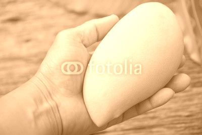 Delicious ripe mango with green leaf in hand  on wooden background.