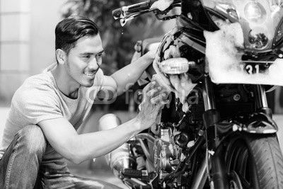 Asian man washing his motorcycle or scooter