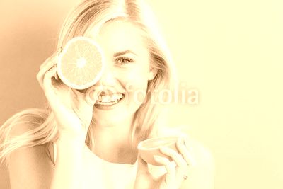Happy young woman holding orange halves