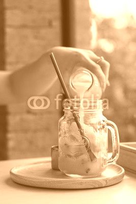 Woman pouring Passion fruit juice in the jar of passion fruit juice ice cube.