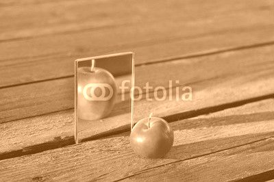 Little Apple is reflected in the mirror. But the reflection looks like the big Apple
