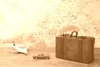 Trip or traveling by airplane concept. Miniature toy airplane and suitcases on map.