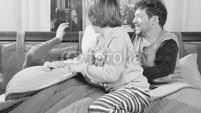 Family having pillow fight in bed slow motion