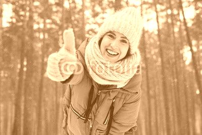 Cheerful young woman holding thumb up showing approval