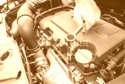 Mani che riparano un motore di automobile con una chiave