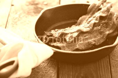 Sizzling hot bacon in a cast iron skillet
