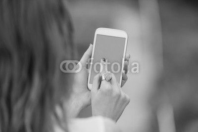 Girl using cellphone outdoors.
