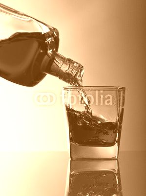 bottle and glass of whiskey on a glass table